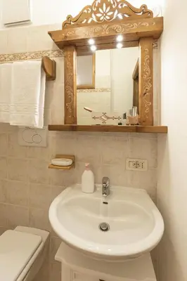 a bathroom with a sink and a mirror and a toilet at Casa Col 2, near ski slopes in Cortina d Ampezzo in Cortina dʼAmpezzo