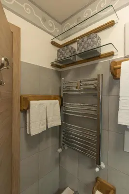 a bathroom with a shower and a toilet and towels at Casa Col 2, near ski slopes in Cortina d Ampezzo in Cortina dʼAmpezzo