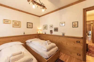 a bedroom with two beds and a mirror at Casa La Marignana, ricca di comfort a Cortina d Ampezzo in Cortina dʼAmpezzo