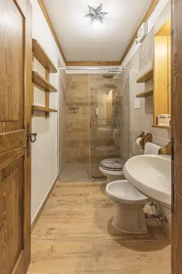 a bathroom with two toilets and a shower at Casa La Marignana, ricca di comfort a Cortina d Ampezzo in Cortina dʼAmpezzo