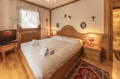 a bedroom with a large bed with towels on it at Casa La Marignana, ricca di comfort a Cortina d Ampezzo in Cortina dʼAmpezzo