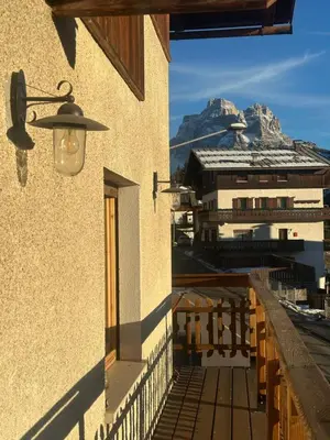 a building with a street light and a mountain at Appartamento PELMO in Selva di Cadore