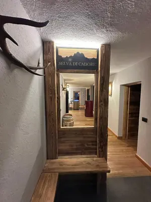 a hallway with a wooden door with a sign on the wall at Appartamento PELMO in Selva di Cadore
