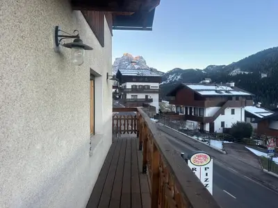 a balcony of a building with a view of a city at Appartamento PELMO in Selva di Cadore