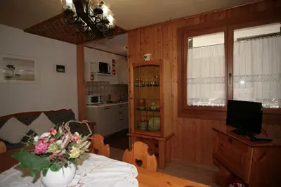 a living room with a vase of flowers on a table at Appartamento Doleda in Canazei