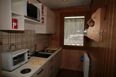 a small kitchen with a microwave and a sink at Appartamento Doleda in Canazei
