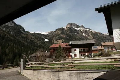 a view of a mountain with a town and a building at Appartamento Doleda in Canazei