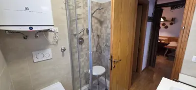 a shower in a bathroom with a glass shower stall at Casa Vaiolet in Pozza di Fassa