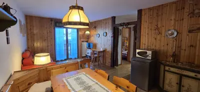 a living room with wooden walls and a table and a lamp at Casa Vaiolet in Pozza di Fassa