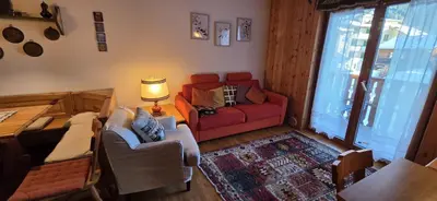 a living room with a red couch and a red chair at Casa Vaiolet in Pozza di Fassa