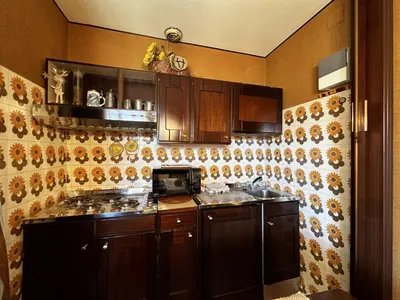 a kitchen with wooden cabinets and a stove top oven at Cortina Chalet Skyview in Zuel