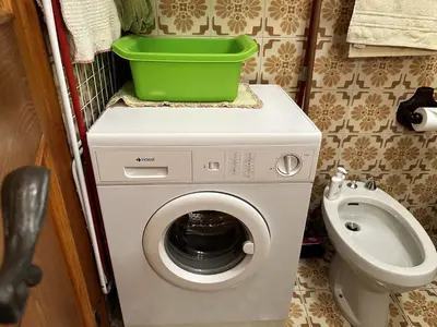 a washing machine with a green bucket on top of it at Cortina Chalet Skyview in Zuel