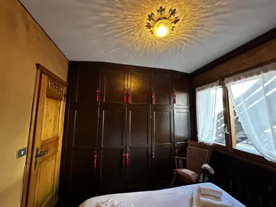 a bedroom with a bed and a ceiling with a chandelier at Cortina Chalet Skyview in Zuel