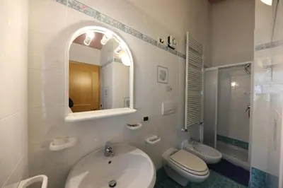 a bathroom with a sink and a toilet and a mirror at Villa Marta in Mazzin