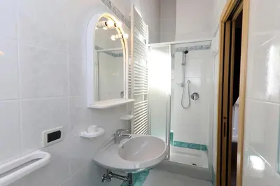 a white bathroom with a sink and a shower at Villa Marta in Mazzin