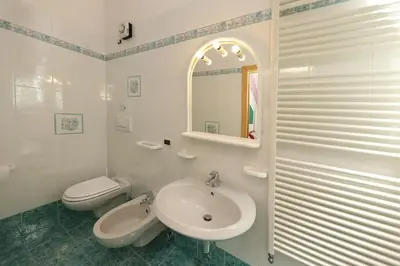 a white bathroom with a sink and a toilet at Villa Marta in Mazzin