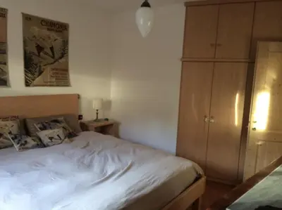 a bedroom with a bed and a wooden cabinet at Maso Gretel in Tesero