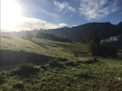 a grassy field with mountains in the background at Maso Gretel in Tesero