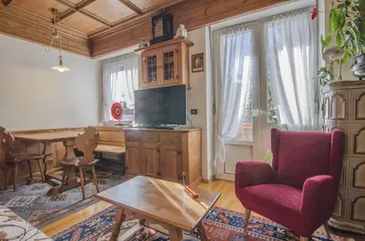 a living room with a desk and a red chair at Nel cuore di Cortina comodo appartamento con parcheggio in Cortina dʼAmpezzo