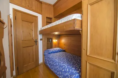 a small bedroom with a bunk bed and a ladder at Nel cuore di Cortina comodo appartamento con parcheggio in Cortina dʼAmpezzo