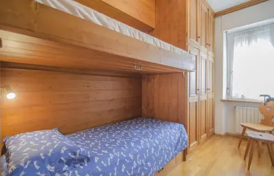 a bedroom with a bunk bed with a wooden wall at Nel cuore di Cortina comodo appartamento con parcheggio in Cortina dʼAmpezzo