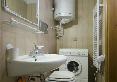 a bathroom with a sink and a washing machine at Nel cuore di Cortina comodo appartamento con parcheggio in Cortina dʼAmpezzo