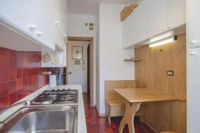 a kitchen with a sink and a stove top oven at Nel cuore di Cortina comodo appartamento con parcheggio in Cortina dʼAmpezzo