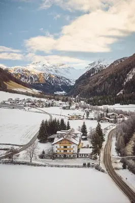 a town in the snow with mountains in the background at Apartments Knappenhof Pfitsch - with Swimming Pool in Val di Vizze