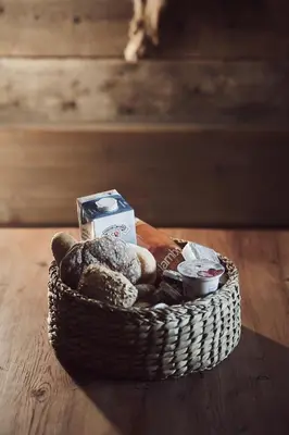a basket of food on a wooden table at Apartments Knappenhof Pfitsch - with Swimming Pool in Val di Vizze