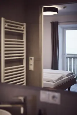a reflection of a bedroom with a bed in a mirror at Apartments Knappenhof Pfitsch - with Swimming Pool in Val di Vizze