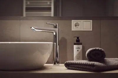 a bathroom sink with a bottle of soap on a counter at Apartments Knappenhof Pfitsch - with Swimming Pool in Val di Vizze
