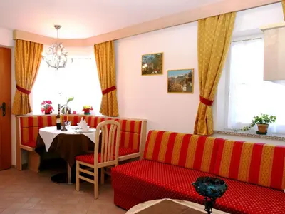 a living room with a red couch and a table at Apartment Cesa Vedla DOLOMITES by Interhome in Bulla