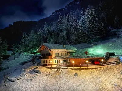 a house in the middle of a snow covered forest at night at Apartment Cesa Vedla DOLOMITES by Interhome in Bulla