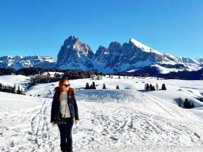 a woman standing in the snow with mountains in the background at Apartment Cesa Vedla DOLOMITES by Interhome in Bulla
