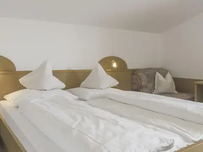 a bed with white sheets and pillows on it at Apartment App- Haselstaude by Interhome in Maranza