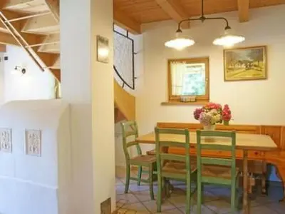a dining room with a table and green chairs at Holiday Home Romantisches Chalet in den Wiesen der Dolomiten by Interhome in Mezzano