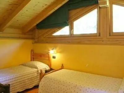 two beds in a room with two windows at Holiday Home Romantisches Chalet in den Wiesen der Dolomiten by Interhome in Mezzano