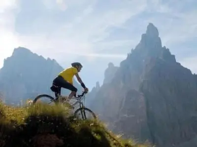 a man riding a bike on top of a mountain at Holiday Home Romantisches Chalet in den Wiesen der Dolomiten by Interhome in Mezzano