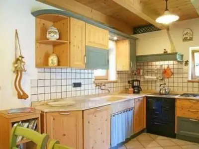 a kitchen with wooden cabinets and a counter top at Holiday Home Romantisches Chalet in den Wiesen der Dolomiten by Interhome in Mezzano