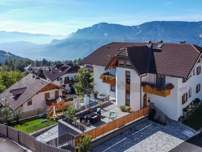 an aerial view of a house with mountains in the background at Apartment Wohnung Valentin by Interhome in Meltina