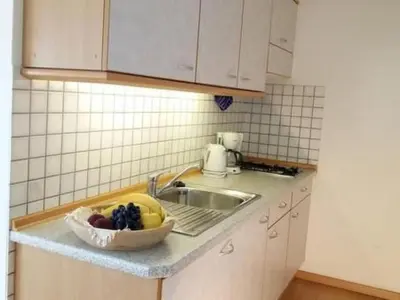 a kitchen with a sink and a bowl of fruit on a counter at Apartment Wohnung Valentin by Interhome in Meltina