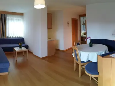 a living room with a table and a blue couch at Apartment Wohnung Valentin by Interhome in Meltina