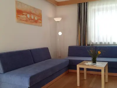 a living room with a blue couch and a table at Apartment Wohnung Valentin by Interhome in Meltina