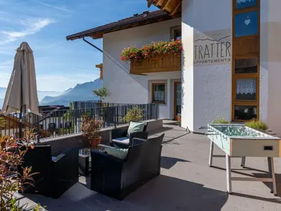 a patio with chairs and a table and an umbrella at Apartment Wohnung Valentin by Interhome in Meltina