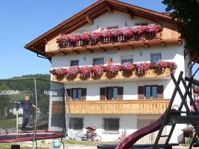 a man standing in front of a building with flowers at Apartment Rosenheim Appartement 2 by Interhome in Maranza