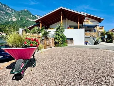 a pink wheelbarrow with flowers in it in front of a house at Apartment Bergblick by Interhome in Castelvecchio