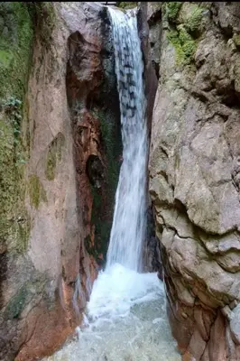 a waterfall on the side of a rocky cliff at Apartment Bergblick by Interhome in Castelvecchio