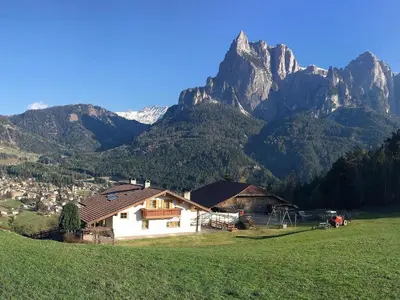 a house in a field with mountains in the background at Apartment in Seis by Interhome in Siusi