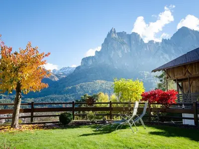 a chair sitting in a yard with a view of mountains at Apartment in Seis by Interhome in Siusi