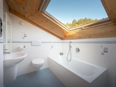 a bathroom with a tub and a toilet and a window at Apartment in Seis by Interhome in Siusi
